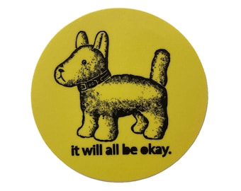 May include: A yellow circular sticker featuring a black and white illustration of a dog wearing a collar. The text "it will all be okay." is printed below the dog.
