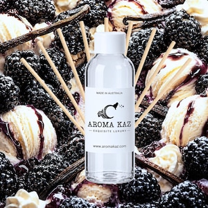 May include: A clear glass reed diffuser bottle with a white cap and a white label featuring the text "MADE IN AUSTRALIA", "AROMA KAZ", "EXQUISITE LUXURY", and "www.aromakaz.com", surrounded by several thin wooden reeds arranged in a fan shape.