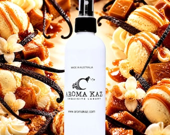 May include: White spray bottle with a black cap, featuring the "Aroma Kaz" logo and text "Made in Australia." The background includes caramel, vanilla beans, and ice cream, suggesting a dessert or fragrance theme.