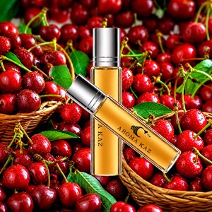 Op de afbeelding: Twee parfumflesjes met zilveren doppen en amberkleurige vloeistof, met het label "Aroma Kaz", worden getoond tegen een achtergrond van verse rode kersen en groene bladeren. De flesjes zijn schuin geplaatst, wat het productontwerp en het kersenthema benadrukt.