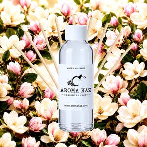 May include: A clear glass reed diffuser bottle with a white cap and a white label featuring the text MADE IN AUSTRALIA, the Aroma Kaz logo, and the website www.aromakaz.com. Several light-colored wooden diffuser reeds fan out from the bottle.
