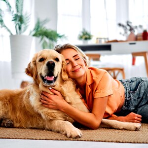 Woman relaxing at home with golden retriever dog in fresh-smelling living room using pet-safe vegan room linen spray air freshener