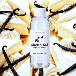 May include: A clear plastic bottle with a white cap and a white label featuring the text MADE IN AUSTRALIA, a logo with the letter C, AROMA KAZ, EXQUISITE LUXURY, and www.aromakaz.com, centred over a background of cheesecake slices and vanilla beans.