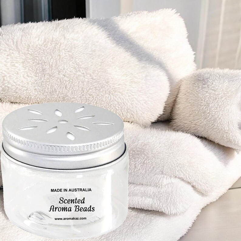 Handmade scented aroma beads air freshener jar on folded towels, made in Australia, vegan and cruelty-free long-lasting fragrance for bathrooms, linens, wardrobes and small spaces.