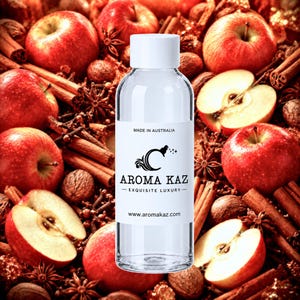 May include: A clear plastic bottle with a white cap and a white label featuring the text MADE IN AUSTRALIA, AROMA KAZ, EXQUISITE LUXURY, and www.aromakaz.com. The bottle is centered against a background of red apples, cinnamon sticks, and spices.