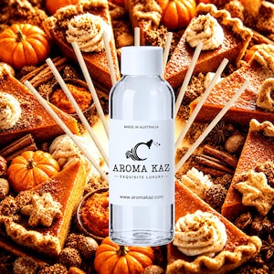 May include: A clear glass reed diffuser bottle with a white cap and a white label featuring the text AROMA KAZ, EXQUISITE LUXURY, MADE IN AUSTRALIA, and www.aromakaz.com, surrounded by several thin wooden reeds extending outward from the bottle.