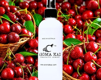May include: White spray bottle with a black cap, featuring the text "AROMA KAZ EXQUISITE LUXURY" and "Made in Australia." The bottle is set against a background of fresh red cherries in woven baskets.