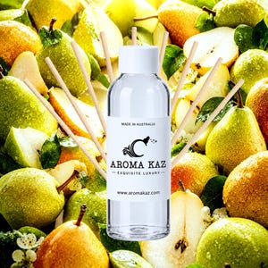 May include: A clear glass reed diffuser bottle with a white cap and a white label featuring the text MADE IN AUSTRALIA, AROMA KAZ, EXQUISITE LUXURY, and www.aromakaz.com, surrounded by several thin wooden reeds extending outward from the bottle.