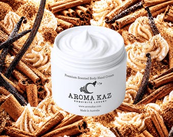 Op de afbeelding: Een witte pot geurige body- en handcrème met een werveling van crème bovenop. De pot is omgeven door kaneelstokjes, vanillestokjes en crème swirls. De tekst op de pot luidt "Premium Scented Body Hand Cream" en "Aroma Kaz Exquisite Luxury".