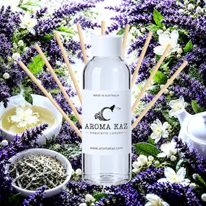 Pode incluir: Um frasco difusor de vidro transparente com tampa branca e um rótulo com os dizeres MADE IN AUSTRALIA, AROMA KAZ, EXQUISITE LUXURY e www.aromakaz.com. O frasco está rodeado por vários palitos difusores de madeira de cor clara.