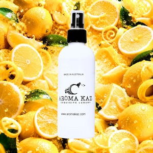May include: A white spray bottle with a black cap, featuring the text "AROMA KAZ EXQUISITE LUXURY" and "MADE IN AUSTRALIA." The bottle is set against a background of fresh lemons and lemon slices.