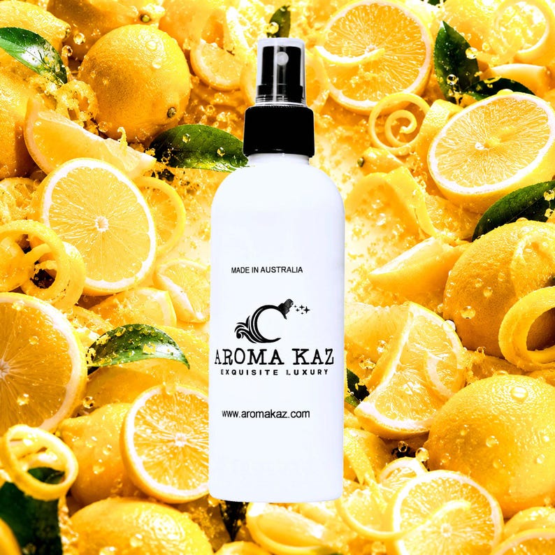 May include: A white spray bottle with a black cap, featuring the text "AROMA KAZ EXQUISITE LUXURY" and "MADE IN AUSTRALIA." The bottle is set against a background of fresh lemons and lemon slices.