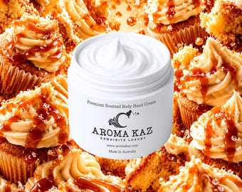 Op de afbeelding: Een witte pot "Premium Scented Body Hand Cream" met de merknaam "Aroma Kaz" staat centraal in de afbeelding. De pot is omringd door cupcakes met karamel drizzle en glazuur. De achtergrond is gevuld met meer cupcakes en stukjes cake.