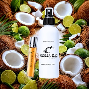 May include: A white spray bottle and a small amber glass roller bottle labelled Aroma Kaz, surrounded by halved coconuts and fresh lime slices. The spray bottle features the text Made in Australia, Aroma Kaz Exquisite Luxury, and the website URL.