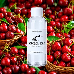May include: A clear plastic bottle with a white cap and a white label featuring the text "MADE IN AUSTRALIA", "AROMA KAZ", "EXQUISITE LUXURY", and "www.aromakaz.com". The bottle is positioned in front of two woven baskets filled with fresh red cherries.