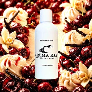 Könnte beinhalten: Weiße Flasche mit weißem Deckel, mit dem Text "AROMA KAZ EXQUISITE LUXURY" und "MADE IN AUSTRALIA". Die Flasche ist umgeben von Kirschen, Vanilleschoten und Sahnewirbeln. Die Website www.aromakaz.com ist ebenfalls sichtbar.