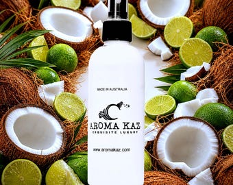 May include: A white spray bottle with a black cap, surrounded by coconuts and lime slices. The bottle has the text "MADE IN AUSTRALIA" and the brand name "AROMA KAZ EXQUISITE LUXURY". The website address www.aromakaz.com is also visible.