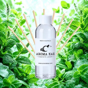 Könnte beinhalten: Eine klare Glasflasche mit weißem Verschluss und einem Etikett mit der Aufschrift MADE IN AUSTRALIA, AROMA KAZ, EXQUISITE LUXURY und www.aromakaz.com. Die Flasche ist von mehreren dünnen, hellen Holzstäbchen für Diffuser in Fächerform umgeben.