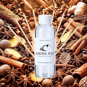 Könnte beinhalten: Eine durchsichtige Glasflasche für einen Raumduft mit weißem Verschluss und einem weißen Etikett mit dem Text AROMA KAZ, MADE IN AUSTRALIA und www.aromakaz.com. Mehrere dünne Holzstäbchen stecken in der Flasche, umgeben von verstreuten Gewürzen.