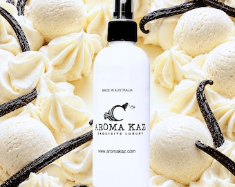 May include: A white spray bottle with a black cap, featuring the text "Aroma Kaz Exquisite Luxury" and "Made in Australia." The bottle is surrounded by vanilla ice cream scoops, whipped cream, and vanilla beans.