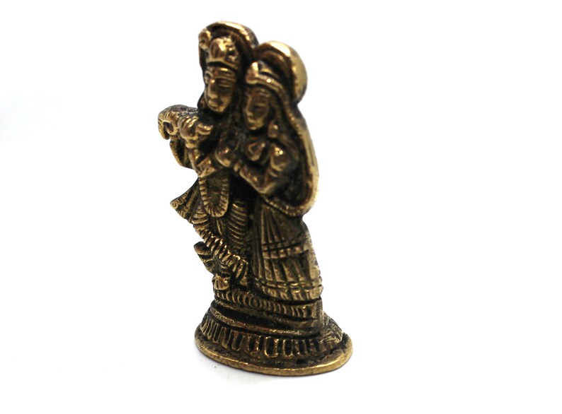 Puede incluir: Una estatua de metal de color dorado de una pareja de pie juntos. La estatua es detallada e intrincada, con la ropa y las joyas de la pareja esculpidas con gran detalle.