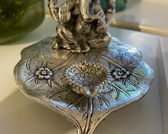 Estatua de Ganesha: Antiguo Señor Ganesha de metal sobre una hoja con lámpara de aceite