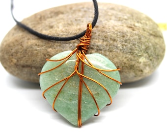 May include: A heart-shaped green aventurine stone wrapped in copper wire, creating a tree-like design. The stone is hanging from a black cord.