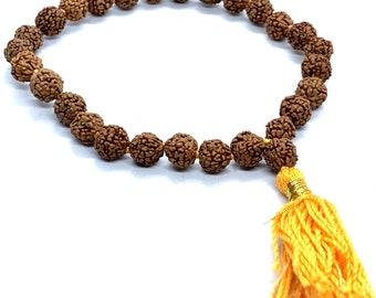 May include: A brown rudraksha mala or prayer beads with a yellow tassel. Rudraksha Gems is printed below the mala.