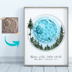 May include: Framed art print featuring a blue and white abstract design within a circular frame, surrounded by watercolor trees. The text "Grow wild. little child" is displayed below the image, along with the baby's name and the month and year.