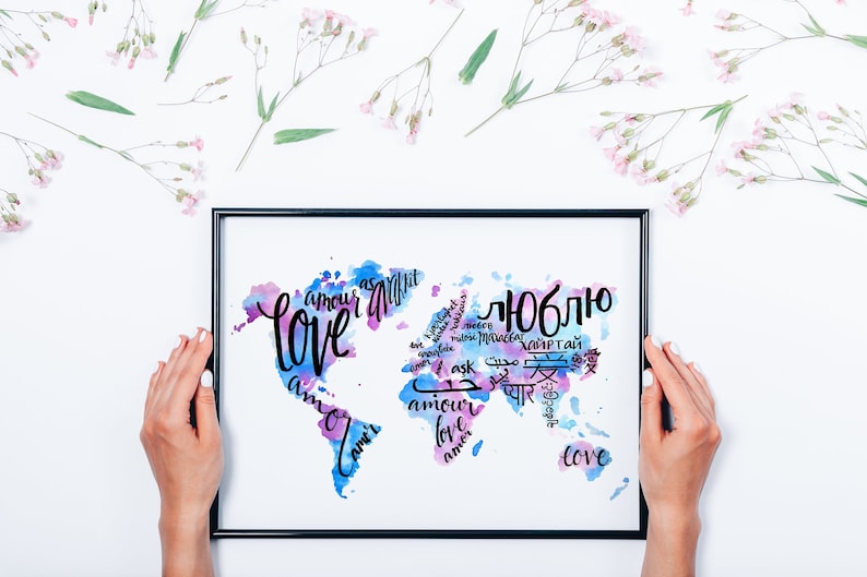 May include: A framed print with a watercolor world map design. The map is filled with the word "love" written in different languages, including English, French, Spanish, Russian, Arabic, and Chinese.