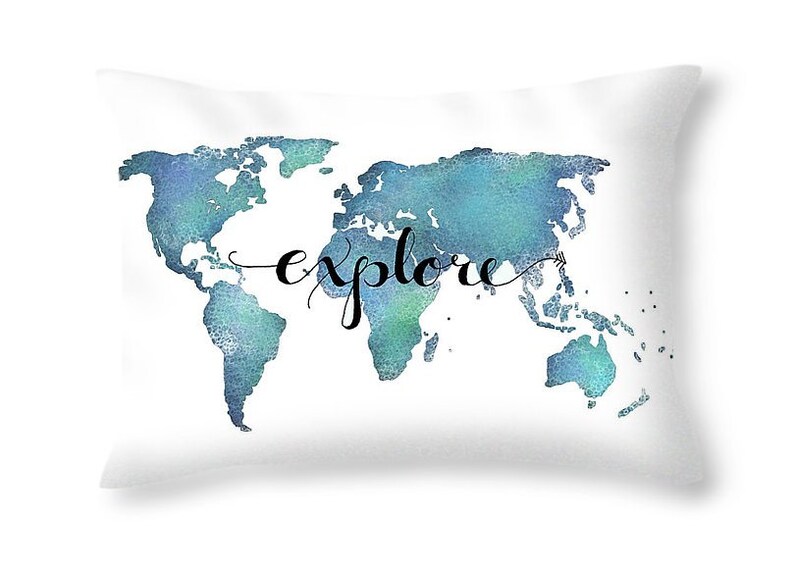 K&ouml;nnte beinhalten: Ein wei&szlig;es Kissen mit einer blauen Aquarell-Weltkarte und dem Wort "explore" in schwarzer Schreibschrift.