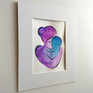 Peut inclure: Peinture &agrave; l'aquarelle d'une figure abstraite de m&egrave;re et d'enfant s'embrassant, en violet et bleu.