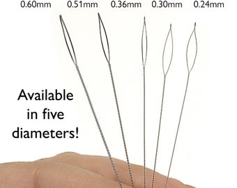 May include: Five different sizes of beading needles, held in a hand. The needles are made of metal and have a loop at the end. The sizes are labeled as Extra Heavy 0.60mm, Heavy 0.51mm, Medium 0.36mm, Fine 0.30mm, and Extra Fine 0.24mm. The text "Available in five diameters!" is also visible.