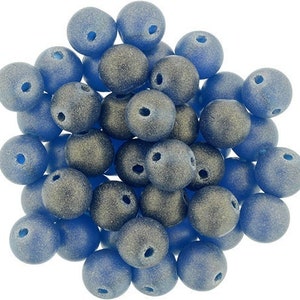May include: A pile of blue and gray round beads. The beads are made of glass and have a matte finish.