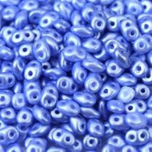 May include: A large quantity of small, light blue, pearlescent glass beads. The beads are shaped like teardrops with two holes.
