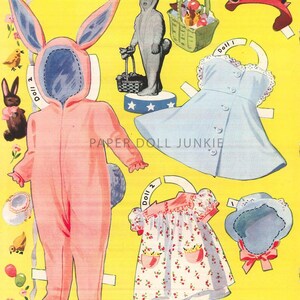 Może przedstawiać: Zestaw papierowych lalek vintage przedstawiający dziewczynkę ubraną w r&oacute;żowy kostium kr&oacute;liczka, niebieską sukienkę z białą koronką i białą sukienkę z kwiatowym wzorem. Zestaw zawiera koszyk z jajkami wielkanocnymi, kapelusz i kr&oacute;liczka.