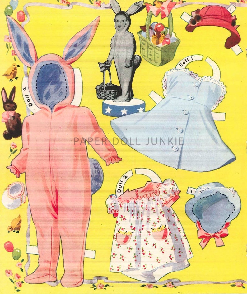 Może przedstawiać: Zestaw papierowych lalek vintage przedstawiający dziewczynkę ubraną w r&oacute;żowy kostium kr&oacute;liczka, niebieską sukienkę z białą koronką i białą sukienkę z kwiatowym wzorem. Zestaw zawiera koszyk z jajkami wielkanocnymi, kapelusz i kr&oacute;liczka.