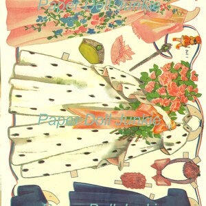 Peut inclure: Un ensemble de poup&eacute;es en papier vintage repr&eacute;sentant une femme dans une robe blanche &agrave; pois noirs, une robe rose &agrave; imprim&eacute; floral et une robe bleue. L'ensemble comprend des accessoires comme un chapeau, un bouquet de roses et une baguette.