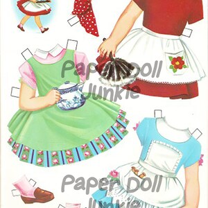 Puede incluir: Un conjunto de mu&ntilde;ecas de papel vintage con tres atuendos diferentes. Los atuendos incluyen un vestido rojo con un delantal blanco y un lazo rojo, un vestido verde con un delantal blanco y una tetera azul, y un vestido azul con un delantal blanco y una plancha. El conjunto de mu&ntilde;ecas de papel es perfecto para juegos imaginativos.