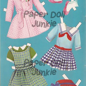 Puede incluir: Un conjunto de mu&ntilde;eca de papel con un abrigo rosa, un vestido de marinero azul y blanco, un vestido de cuadros verdes y blancos, un sombrero rojo y un par de zapatos rosas.