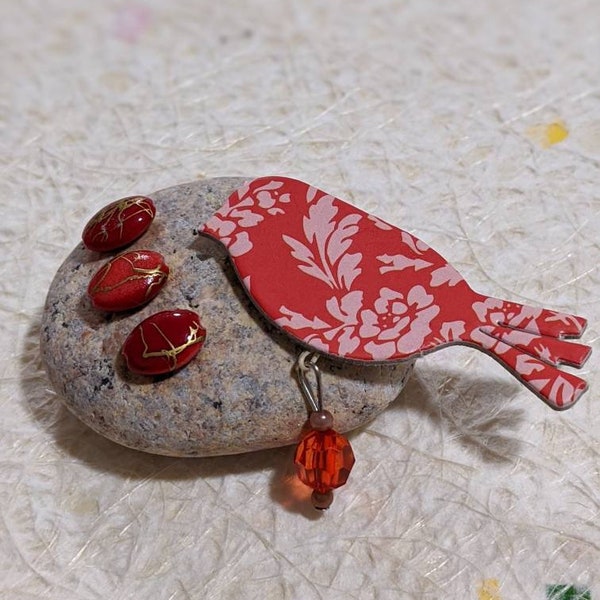 Decorative red and pink robin resting on a beach pebble nesting over her eggs.  Gift for bird lover/bird enthusiast. Birds nest. Paperweight