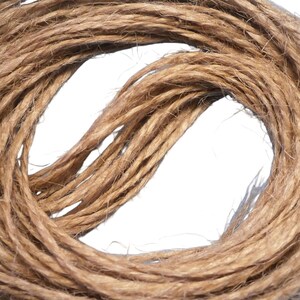 May include: A close-up of a coil of natural brown twine. The twine is made of natural fibres and is perfect for crafting, gardening, and other DIY projects.