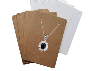 May include: A silver necklace with a black oval pendant and white stone detailing, presented on brown and white jewellery display cards. The cards are fanned out, highlighting the necklace's design.
