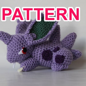 Puede incluir: Patrón de crochet para un amigurumi Pokémon morado y verde. El patrón incluye instrucciones para hacer los ojos, las orejas y el cuerpo del personaje.