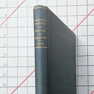May include: A dark teal hardcover book with the title "PRINCIPLES AND PRACTICE OF PERIMETRY PETER" in gold lettering. The spine and cover are dark teal. The book has a gold emblem on the cover.
