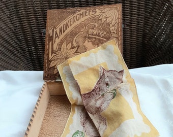 May include: A wooden box with a hinged lid, the lid is open and a yellow handkerchief with a squirrel design is partially pulled out of the box. The lid of the box has the words "HANDKERCHIEFS" printed on it.