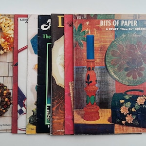 May include: A collection of eight vintage craft books with colorful covers. The books are titled "Bits of Paper", "Leisure Arts", "The Flower Arranger", "Doll Clothes", "Bits of Paper", "Bits of Paper", "Bits of Paper", and "Bits of Paper".