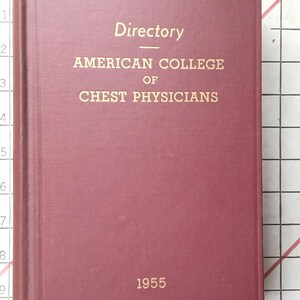 May include: A maroon-colored book titled "Directory" with gold lettering. The text reads "AMERICAN COLLEGE OF CHEST PHYSICIANS" and "1955". The book is closed and appears to be in good condition.