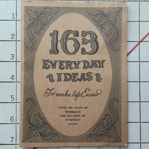 Könnte beinhalten: Ein Vintage-Buchcover mit braunem Hintergrund und einem dekorativen Rand. Der Titel lautet "163 EVERY DAY IDEAS 1. To make life Easier" und der Text "FROM THE PAGES OF WEEKDAY THE MAGAZINE OF EVERYDAY LIVING" ist unter dem Titel gedruckt.