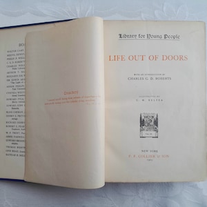 May include: A vintage book titled "Life Out of Doors" by Charles G. D. Roberts, illustrated by C.M. Relyea. The book is part of the "Library for Young People" series and was published in 1901 by P.F. Collier & Son in New York.